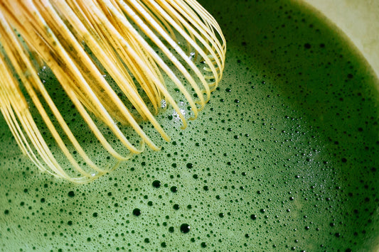 Ceremonial Grade Matcha green tea being whisked with bamboo whisk